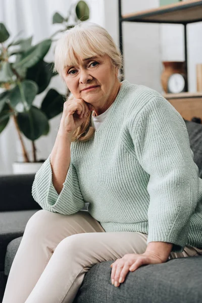 Sorgliga Pensionerad Kvinna Med Blont Hår Sitter Soffa — Stockfoto