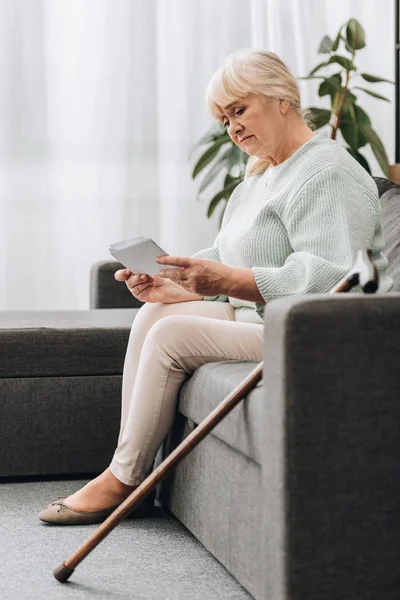 Sad Retired Woman Blonde Hair Looking Photos While Sitting Sofa — Stock Photo, Image