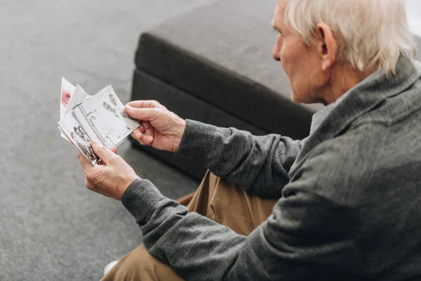 Pensionerad Man Med Grått Hår Tittar Gamla Bilder Hemma — Stockfoto