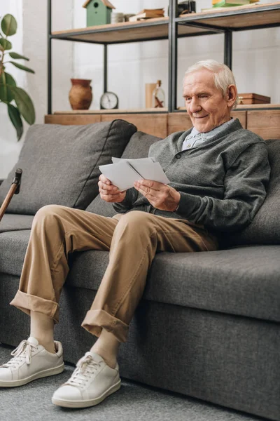 Hombre Jubilado Sonriente Con Pelo Gris Mirando Fotos Sentado Sofá — Foto de Stock