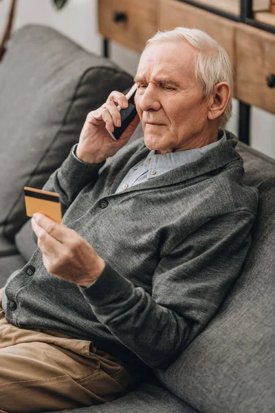 Старший Чоловік Розмовляє Смартфону Дивиться Кредитну Картку — стокове фото