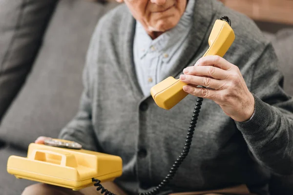 Vista Ritagliata Uomo Anziano Possesso Telefono Retrò Casa — Foto Stock