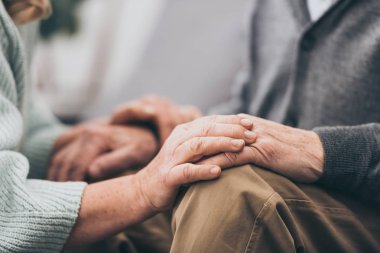 cropped view of retired couple holding hands  clipart