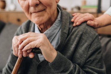 cropped view of happy pensioner with wife hands on shoulder  clipart