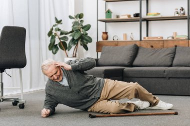old men falled down on floor and touching head clipart