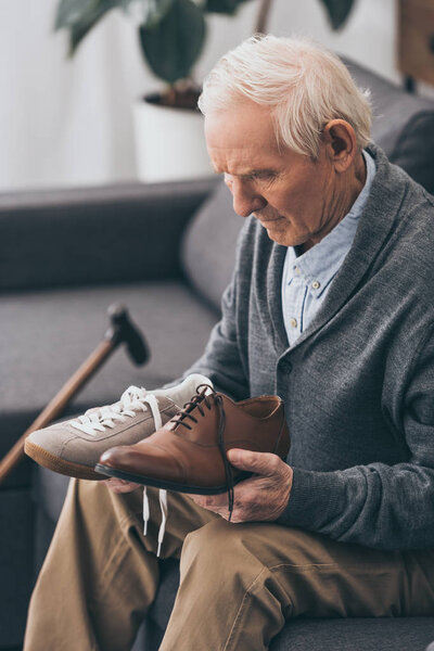 senior man choosing between classic and modern shoes