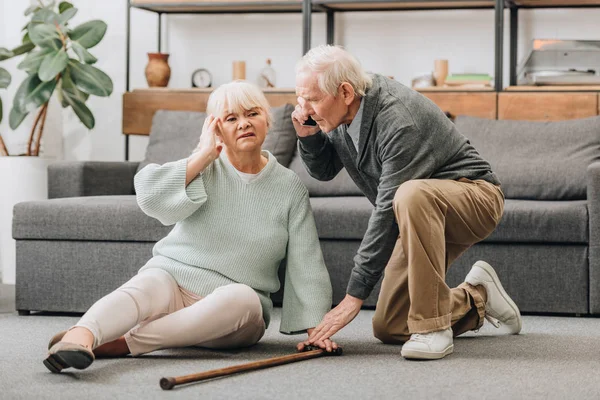 Senior Wife Sitting Floor While Supportive Retired Husband Talking Smartphone — Stock Photo, Image