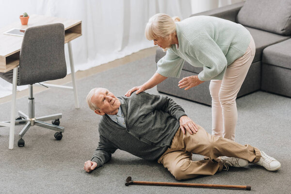 old woman looking at husband who falled down on floor