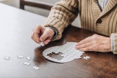 oříznutý pohled starší muž si hraje s puzzle 