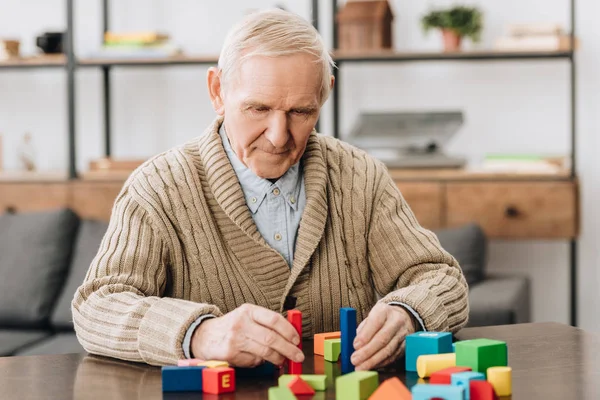 Senior Man Spelen Met Houten Speelgoed Thuis — Stockfoto