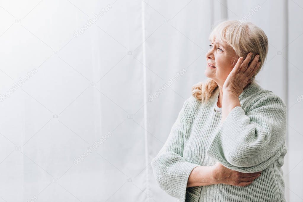 retired woman with blonde hair having headache 