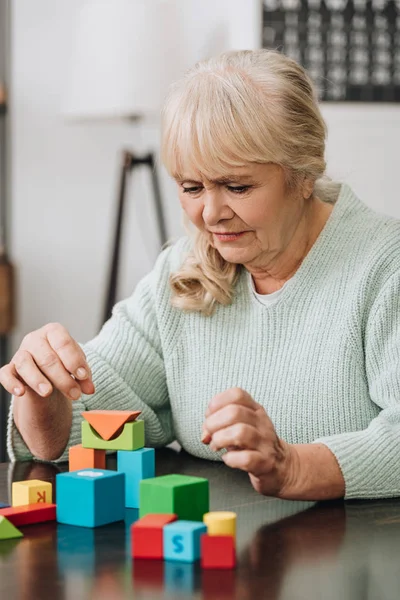 Blonde Senior Woman Playing Wooden Toys Home — Stock Photo, Image