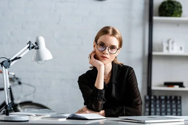 Vacker Affärskvinna Svarta Kläder Och Glasögon Sitter Stol Och Hålla — Stockfoto