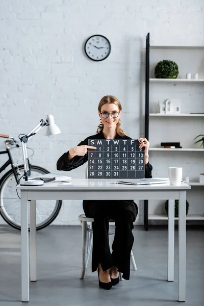 Attraktive Geschäftsfrau Schwarzer Kleidung Und Brille Zeigt Kalender — Stockfoto