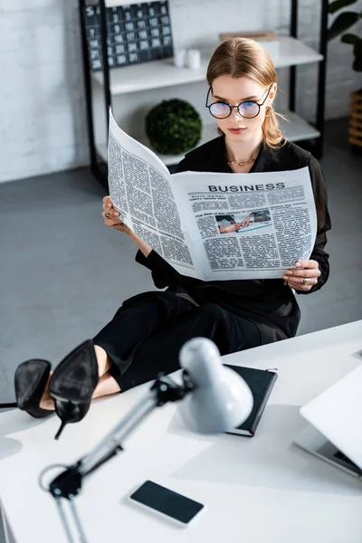 Beautiful Businesswoman Black Clothes Shoes Sitting Table Holding Newspaper — Stock Photo, Image