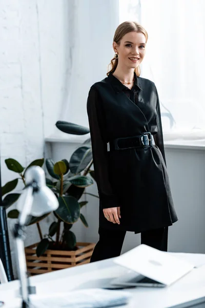 黒服のオフィスでカメラに笑顔の美しい女性実業家 — ストック写真