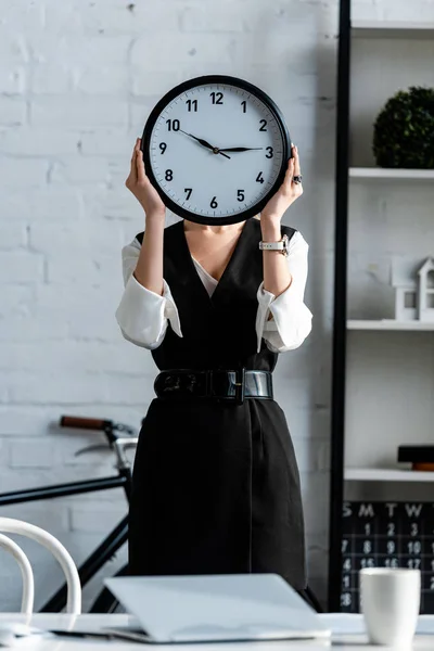 職場で顔の前で時計を保持している正式な摩耗で実業家の選択と集中 — ストック写真