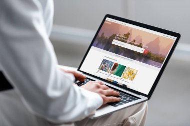 cropped view of woman using laptop with shutterstock website on screen clipart