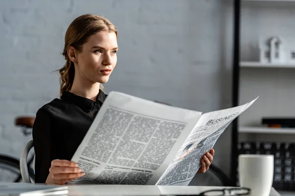 Beautiful Businesswoman Black Formal Wear Sitting Desk Reading Newspaper Workplace — Stock Photo, Image
