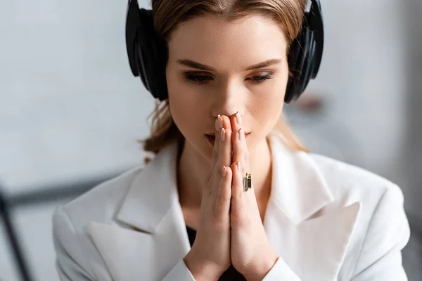 portrait of beautiful woman in headphones with folded hands
