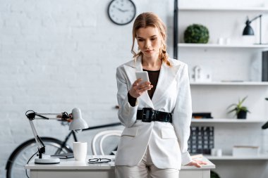 İşyerinde smartphone kullanarak beyaz resmi aşınmaya ciddi iş kadını