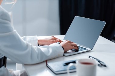 ofis büro ofis masası, boş ekran ile dizüstü bilgisayar kullanan kadın kırpılmış görünümünü