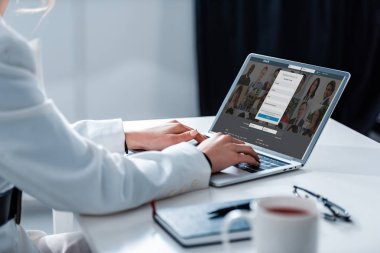 Kırpılan görünümünü LinkedIn Web sitesinde ofis masası ekranında ile dizüstü bilgisayar kullanan kadın