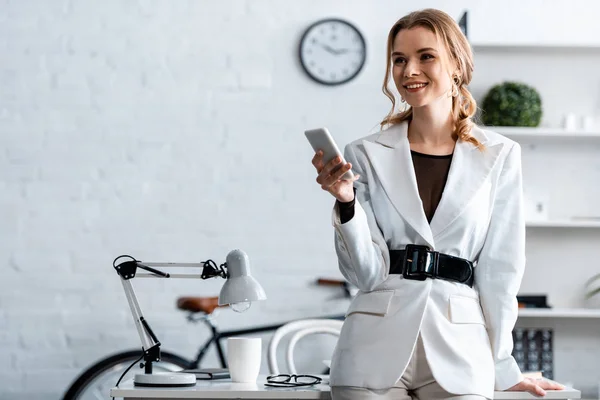 Lächelnde Geschäftsfrau Weißer Dienstkleidung Mit Smartphone Arbeitsplatz — Stockfoto