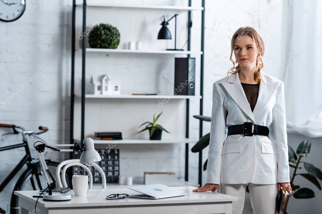 concentrated businesswoman in formal wear looking away in modern office interior 
