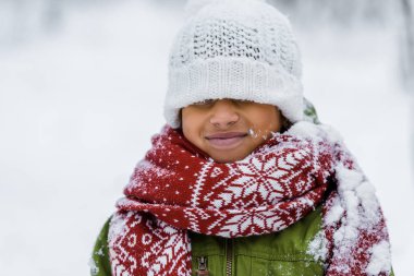 Kışın gözlerinin önüne çekti örme şapka ile Afro-Amerikan çocuk sıcak giyim gülümseyen