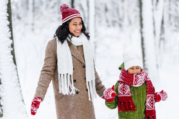 Vrolijke Afro Amerikaanse Moeder Schattig Kind Permanent Tijdens Sneeuwval Winter — Stockfoto