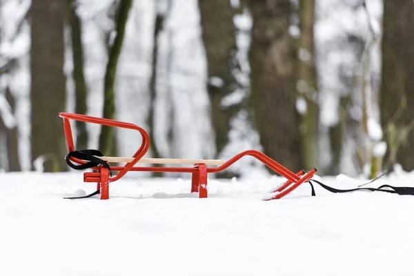 Roter Schlitten Auf Schnee Mit Bäumen Hintergrund — Stockfoto