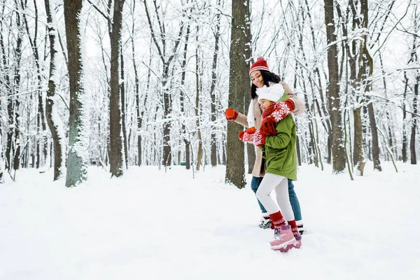 Atractiva Madre Afroamericana Linda Hija Caminando Sosteniendo Copas Bosque Nevado — Foto de Stock