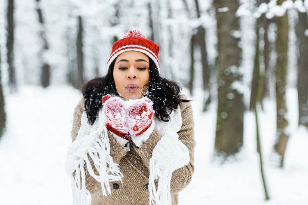 Atractiva Mujer Afroamericana Soplando Nieve Cerca Los Árboles Bosque Invierno —  Fotos de Stock