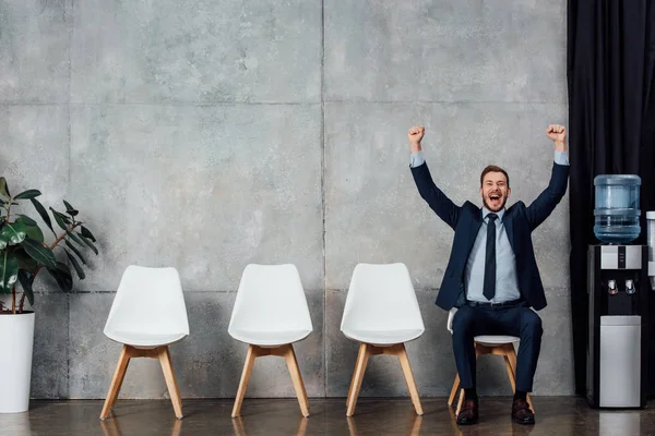 Excited Businessman Sitting Chair Cheering Clenched Fists Waiting Hall — Stock Photo, Image