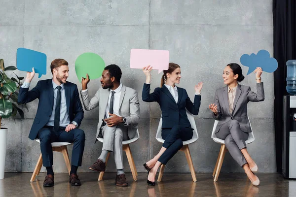 Happy Multiethnic Businesspeople Holding Speech Bubbles Thought Bubble While Sitting — Stock Photo, Image