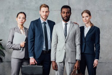 confident multiethnic group of businesspeople in formal wear looking at camera 