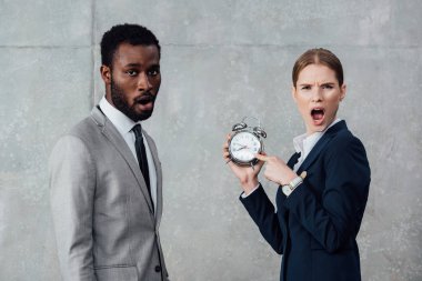 şok işkadını saat Afrikalı-Amerikalı işadamı kameraya gri arka plan üzerinde seyir sırasında işaret