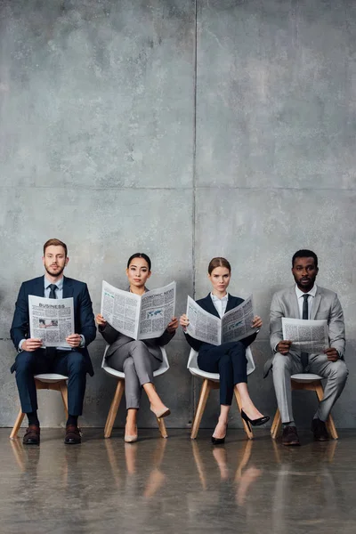 Serious Multiethnic Businesspeople Sitting Chairs Reading Newspapers Waiting Hall — Stock Photo, Image