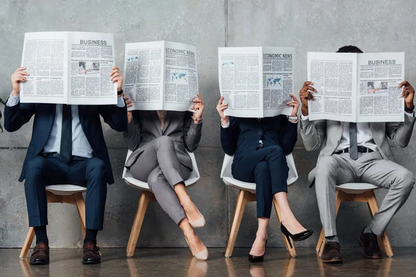 Empresarios Ropa Formal Sentados Sillas Sosteniendo Periódicos Frente Las Caras — Foto de Stock