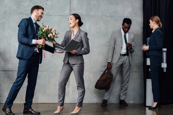 Zakenman Presenteren Bloemen Zakenvrouw Met Multi Etnisch Collega Achtergrond Wachten — Stockfoto