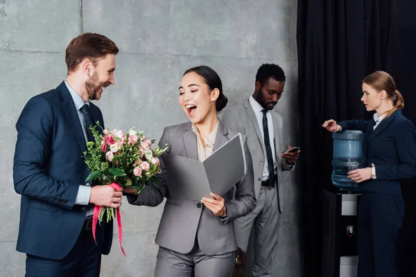 Hombre Negocios Presentando Flores Alegre Mujer Negocios Asiática Con Colegas —  Fotos de Stock