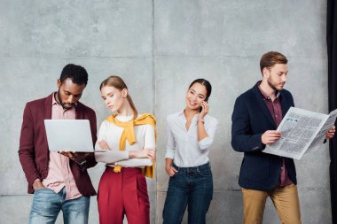 dijital cihazlar kullanarak ve bekleme salonunda gazete okuma çok ırklı rahat iş adamları