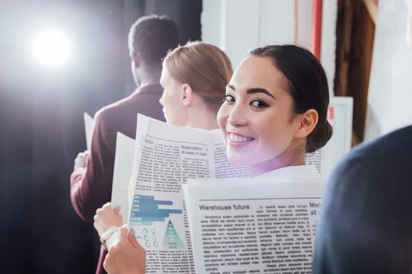 Attractive Asian Businesswoman Looking Camera Holding Newspaper Colleagues Background — Stock Photo, Image