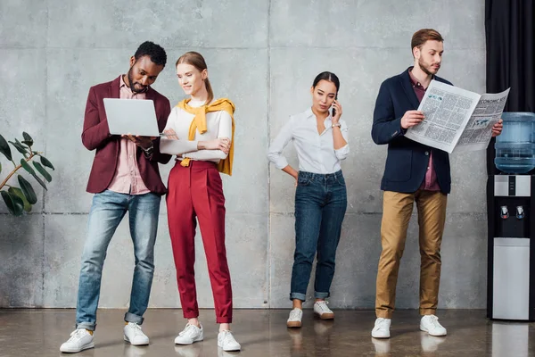 dijital cihazlar kullanarak ve bekleme salonunda gazete okuma meşgul çok ırklı rahat iş adamları