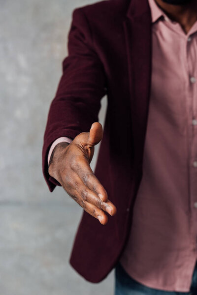 partial view of american man outstretching hand for handshake