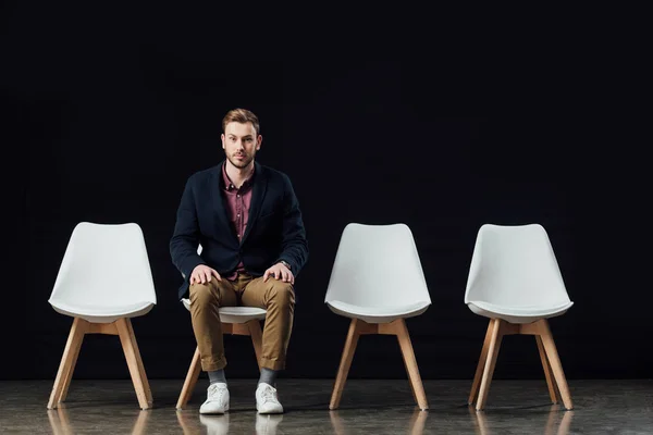 Serious Man Sitting Chair Looking Camera Isolated Black — Stock Photo, Image