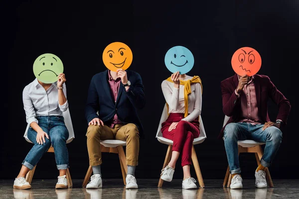 Grupo Personas Sentadas Sillas Sosteniendo Tarjetas Faciales Con Varias Emociones — Foto de Stock