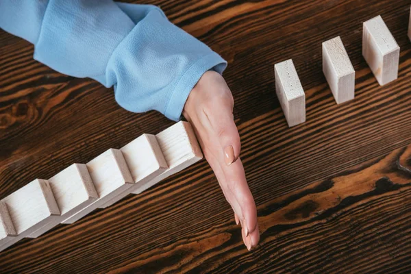 Cropped View Woman Sitting Desk Preventing Wooden Blocks Falling Hand — Stock Photo, Image