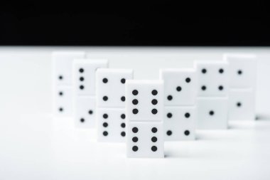 selective focus of domino row isolated on black clipart